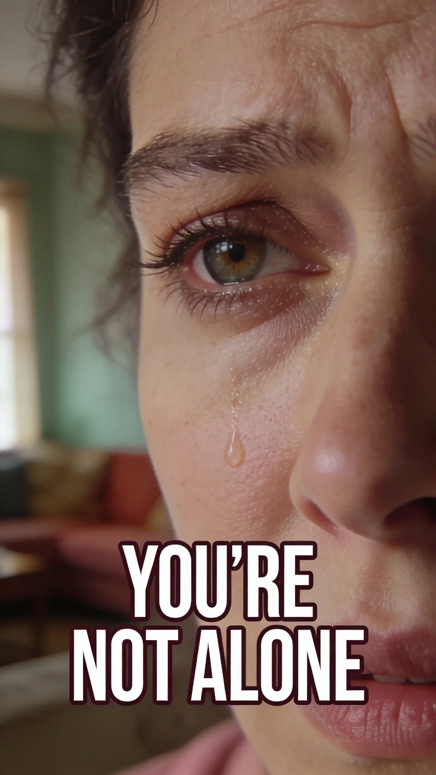 CLOSE-UP FACE EMOTION: extreme close-up of one face (parent or child), eyes in sharp focus, BASE: vertical 9:16, ultra-tall composition optimized for mobile Pinterest feed, SCENE: An extreme close-up of a mother's face, her eyes in sharp focus, reflecting a mixture of profound exhaustion and deep love, with a hint of worry lines around her eyes. Her brow is slightly furrowed, and there's a single tear tracing a path down her cheek, capturing the raw vulnerability and overwhelm of parenting a kindergartener. The background is a soft, blurred wash of muted colors from a dimly lit living room, suggesting the end of a long, challenging day. The emotion is palpable, instantly relatable to overwhelmed parents. , EMOTION HOOK: Overwhelmed parent burnout, TOPIC PHRASE: Mom burnout relief, TEXT POSITION: BOTTOM-CENTER, OVERLAY: text says exactly: "YOU'RE NOT ALONE", bold sans-serif font, high contrast white text with dark outline or shadow so it is readable on mobile, overlay text should be a punchy version of the TOPIC PHRASE or EMOTION HOOK, LIGHT: Soft, natural light from an unseen window, MOOD: Overwhelmed, exhausted, vulnerable, determined, loving, COLOR: muted warm palette (dusty rose, cream, terracotta, soft sage, warm beige), gentle film grain, no logos, no watermarks, photorealistic, 8K, shallow depth of field, film aesthetic, cinematic color grade, no logos, no watermarks